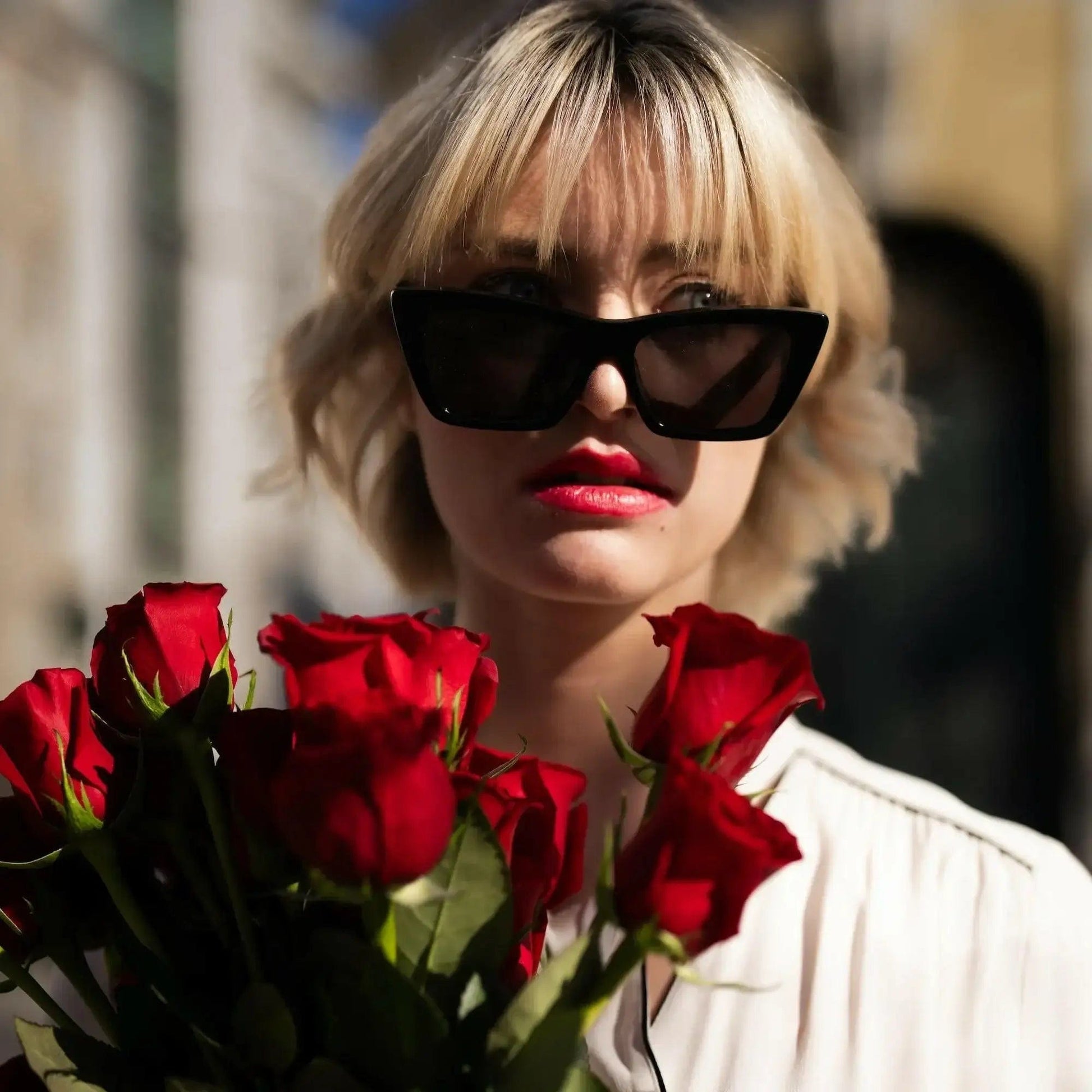 Buquê de Rosas Vermelhas e Chocolates Arcádia - modelo com os óculos pretos e as rosas vermelhas  | QRoses 