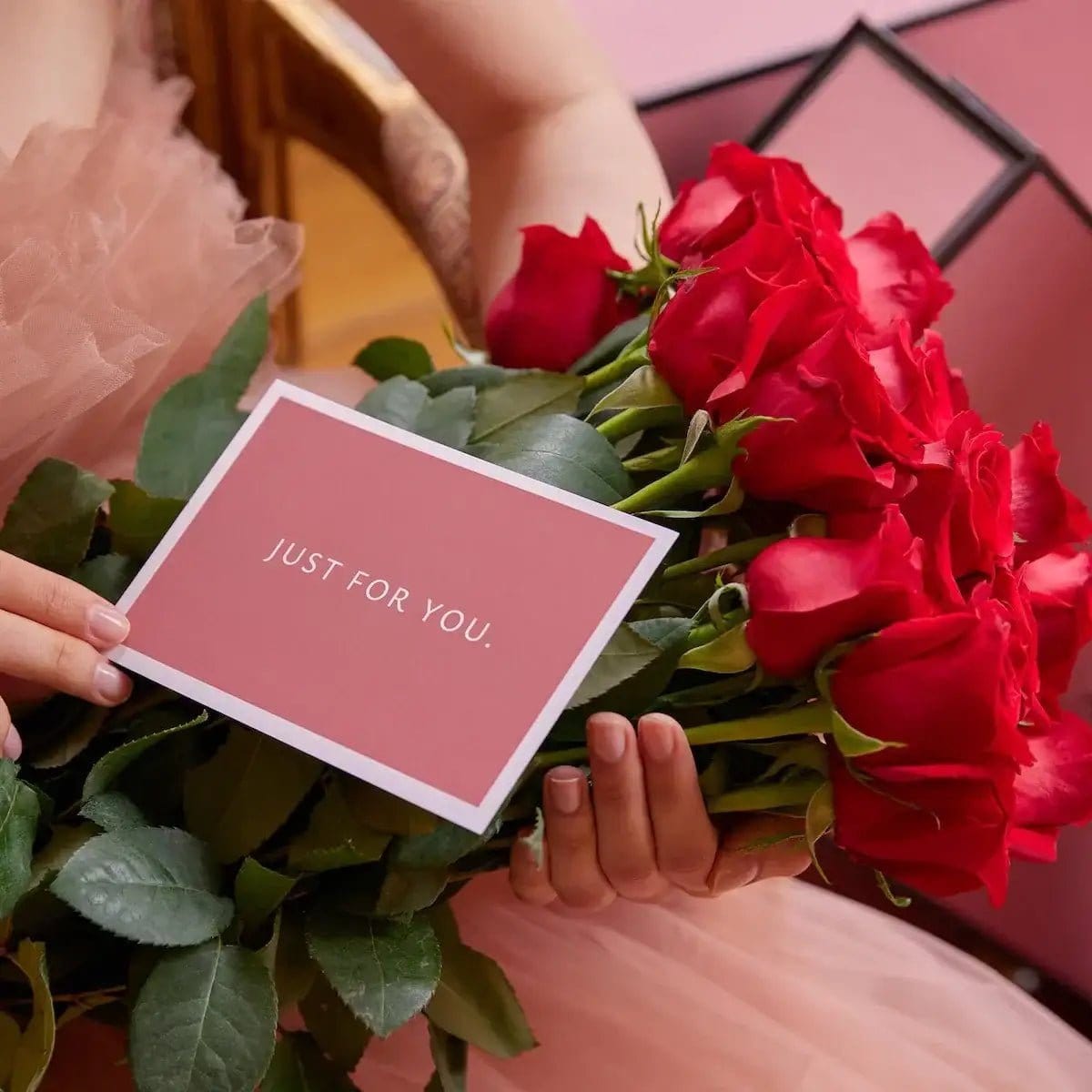 Buquê de rosas vermelhas em caixa de luxo - Modelo a mostrar o cartão Just For You no palácio de Sintra | QRoses